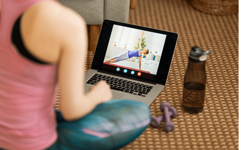 Woman watching workout on laptop screen