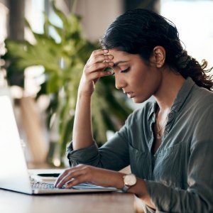 Woman with headache on her laptop